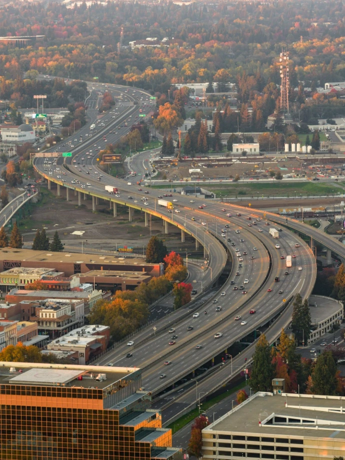 Busy highway interchange with traffic at sunset.